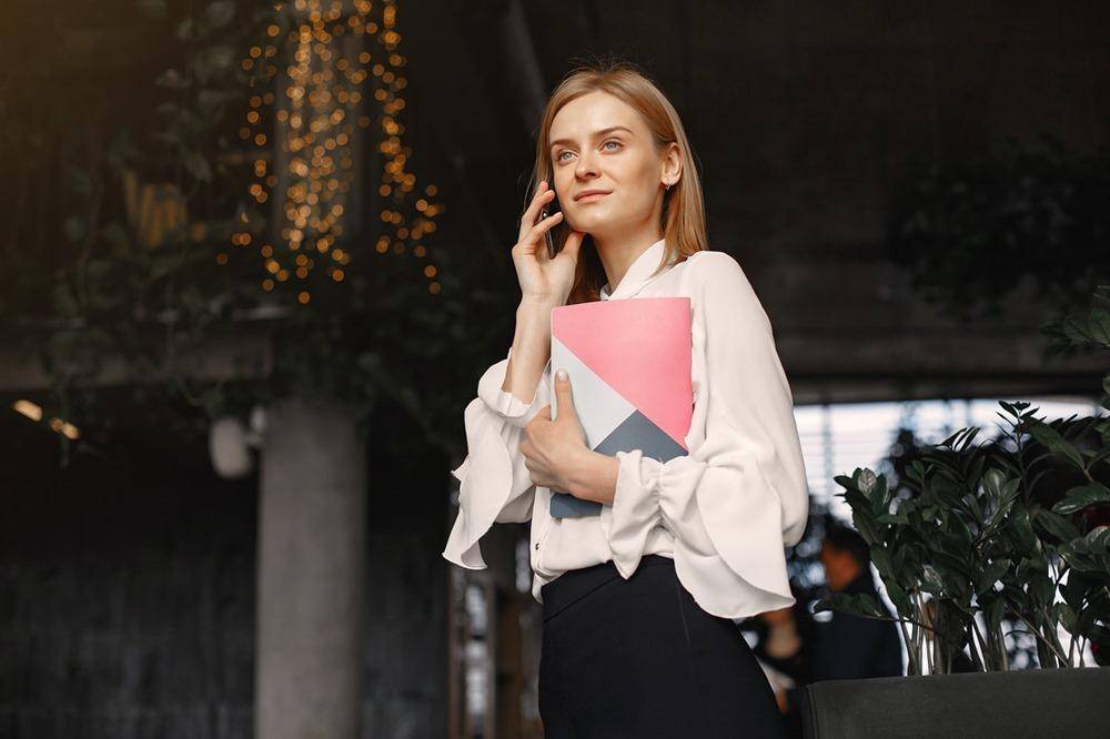 businesswoman-with-notebook-calling-on-smartphone-in-cafe-4173265.jpg